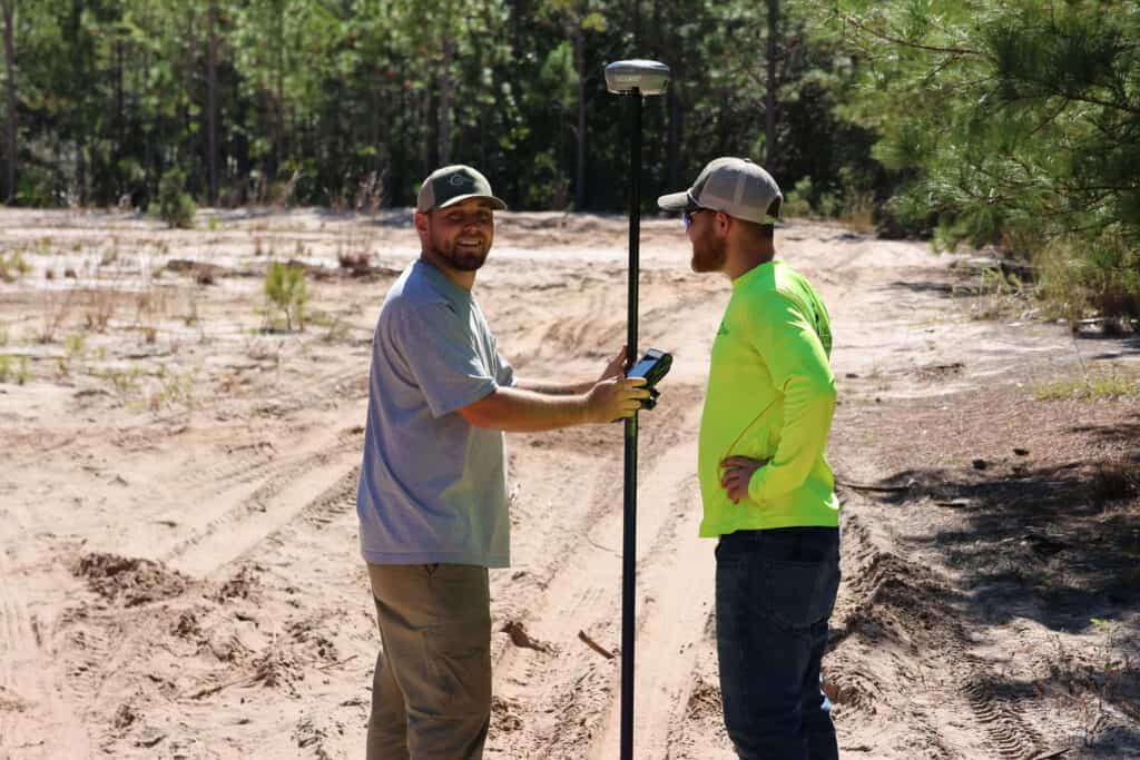 Land surveyors reviewing field data using GPS equipment during boundary surveying