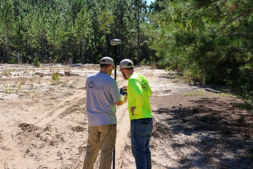 Land surveyors reviewing field data using GPS equipment during boundary surveying