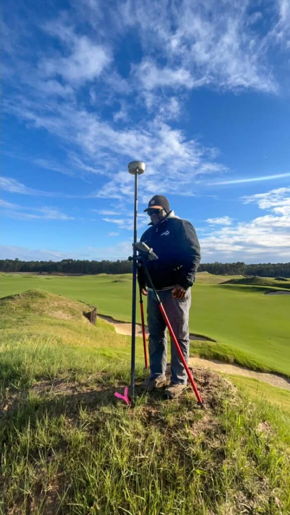Surveyor using GPS equipment to collect field data on a Lowcountry golf course