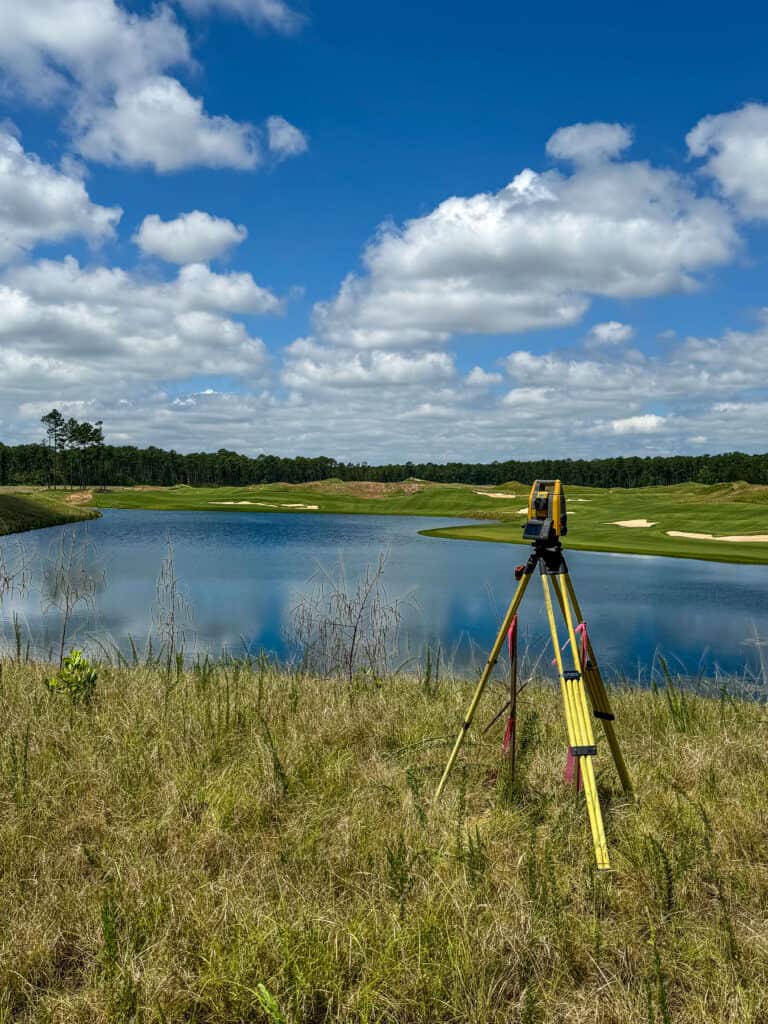 Surveying instrument set up near a water feature on a golf course for a land surveying and site mapping project in the South Carolina Lowcountry
